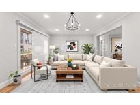 Bright living room with modern chandelier, large sectional sofa, and sliding glass doors at 6851 Roswell Rd # F32, Sandy Springs, GA 30328