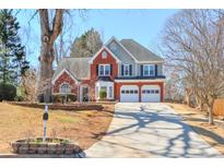 Charming two-story home with brick accents, attached two-car garage, and a long driveway at 893 Lance Cir, Lawrenceville, GA 30043