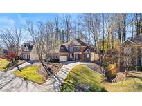 Beautifully landscaped home with a brick facade, mature trees, and a circular driveway at 108 Ardsley Run, Canton, GA 30115