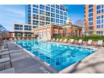 Beautiful outdoor pool with lounge chairs and clear blue water, surrounded by upscale buildings at 1820 Peachtree Nw St # 1207, Atlanta, GA 30309