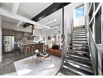 Open-concept living space with modern kitchen, stainless steel appliances, metal stairs, and industrial-chic design at 307 Cherokee Se Ave # 9, Atlanta, GA 30312