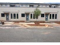 Three story townhome with gray doors, lots of windows and tan brick facade at 003 White St # 3, Marietta, GA 30060
