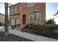 Elegant brick home with an arched entryway, two-car garage and manicured landscaping at 1459 Hedgewood Nw Ln, Kennesaw, GA 30152