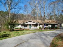 Charming single-story home featuring a welcoming front porch and a long, private driveway at 901 Guys Sw Ct, Lilburn, GA 30047