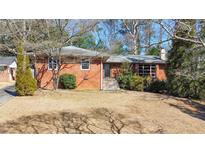 Charming single-story brick home with a well-maintained front yard and mature trees, creating a welcoming curb appeal at 1446 Lively Ridge Ne Rd, Atlanta, GA 30329