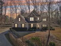 Charming brick two-story home with manicured lawn and mature trees, nestled on a beautifully landscaped lot at 4375 Maverick Nw Ln, Kennesaw, GA 30152