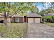 Charming single-Gathering home with a two-car garage, mature tree and manicured lawn at 1522 Burnstone Dr, Stone Mountain, GA 30088