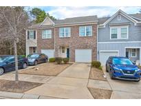 Townhome exterior showcasing brick facade, attached garages, and well-manicured landscaping at 6356 Kennonbriar Ct, Lithonia, GA 30058