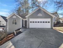 Charming home featuring gray siding, an attached garage, and a concrete driveway at 1831 Killarney Sw Dr, Marietta, GA 30008