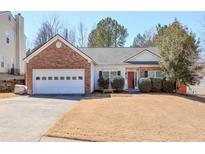 Charming brick and vinyl home featuring a two-car garage and a well-maintained lawn at 845 Johnson Mill Ter, Sugar Hill, GA 30518