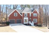 Charming two-story red brick home with a well-manicured front yard and attached two-car garage at 742 Eastwood Rise, Stone Mountain, GA 30087