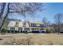 Charming two-story home with a metal roof, inviting front porch, and well-manicured lawn at 1103 Wallington Nw Ct, Conyers, GA 30012