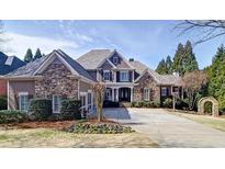 Charming home with stone accents, a long driveway, manicured lawn, and lush landscaping at 2813 Long Grove Ct, Marietta, GA 30062