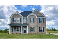 Charming two-story brick home with a well-manicured lawn, black shutters, and a classic design at 625 Egrets Landing Lndg, Covington, GA 30014