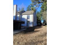 Charming two-story home with a light-colored exterior and well-maintained landscaping at 1 Willowick Dr, Lithonia, GA 30038