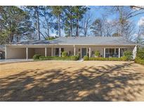 Charming single-story home featuring a covered porch, well-manicured lawn and mature trees at 2034 Eldorado Ne Dr, Atlanta, GA 30345