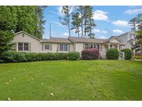 Charming single-story home with a lush green lawn, trimmed hedges, and a welcoming facade at 2107 Old Dallas Sw Rd, Marietta, GA 30064