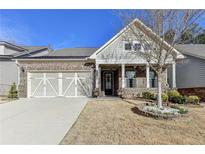 Charming brick home with a manicured lawn, attached garage, and inviting front porch at 3030 Appling Hills Dr, Dacula, GA 30019