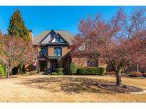 Stately brick home boasts mature trees, manicured landscaping, and an inviting facade with architectural details at 5175 Wilshire Xing, Cumming, GA 30040