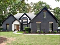 Charming painted brick home with manicured lawn and inviting curb appeal at 110 Roberts Rd, Suwanee, GA 30024