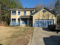 Charming two-story home with a well-maintained lawn and a spacious two-car garage at 2615 Fox Hall Ln, Atlanta, GA 30349