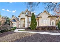 Elegant brick and stucco home featuring a graceful walkway, manicured landscaping, and architectural details at 2679 Wynnton Dr, Duluth, GA 30097