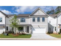 Charming two-story home with a modern design, featuring light gray siding, black trim, and a well-manicured front lawn at 1514 Gatekeeper Ter, Marietta, GA 30066