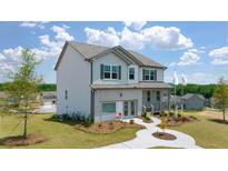 Beautiful two-story home featuring a brick and siding exterior, complemented by a well-manicured lawn and landscaped walkway at 3511 Summerlin Pkwy, Lithia Springs, GA 30122