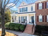 Charming two-story home featuring a welcoming front porch with brick stairs and manicured landscaping at 3760 Lake Point Blvd, Suwanee, GA 30024