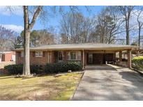 Charming brick home with a carport, mature landscaping, and a spacious driveway at 3806 Lindley Cir, Powder Springs, GA 30127