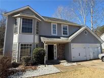 Charming two-story home featuring gray stucco, stone accents, and a two-car garage at 904 Crossing Rock Dr, Lawrenceville, GA 30043