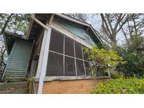 View of the home's exterior featuring a screened porch and weathered facade at 1687 Neely Ave, Atlanta, GA 30344