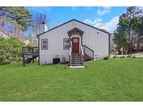 Charming home with a red front door, landscaped yard, and inviting entry stairs at 3242 Kingswood Gln, Decatur, GA 30034