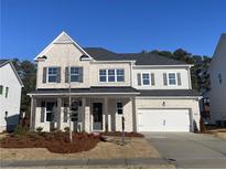 Charming two-story home featuring a brick facade, inviting porch, and a two-car garage, all set under a clear blue sky at 1960 Freestone Way, Marietta, GA 30064
