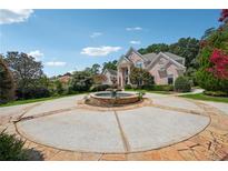 Stunning two-story brick home features a circular driveway with a fountain and lush landscaping at 2225 Johnson Ferry Rd., Marietta, GA 30062