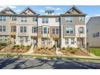 View of townhomes with brick and siding, and landscaped front yards with walkways leading to covered entryways at 967 Allegro Park, Marietta, GA 30067