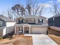 Charming two-story home with brick and siding, a well-manicured lawn, and an attached two-car garage at 1761 Dosk Ave, Lawrenceville, GA 30044