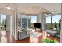 Bright living room with floor-to-ceiling windows offering stunning city views and hardwood floors at 860 Peachtree Ne St # 2001, Atlanta, GA 30308