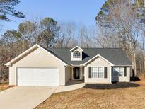 Charming single-story home featuring a two-car garage and well-maintained landscaping at 135 Kimbell Farm Dr, Locust Grove, GA 30248