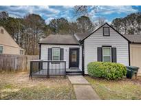 Charming home featuring a modern white exterior with black accents, a cozy front porch, and a well-maintained lawn at 1281 W Booth Road W Ext, Marietta, GA 30008