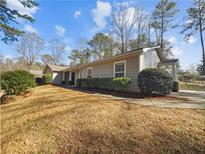 Charming single-story home with landscaped yard and inviting front porch, perfect for relaxing and enjoying the outdoors at 1950 S Inlet, Marietta, GA 30066