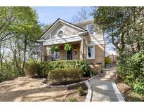 Charming two-story home with inviting front porch, manicured landscaping, and beautiful stone walkway at 750 Clemont Ne Dr, Atlanta, GA 30306