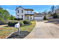 Charming two-story home with a well-manicured front yard and a long driveway at 5065 Timberbridge Ln, Johns Creek, GA 30022