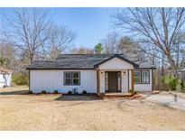 Charming renovated home showcasing a freshly painted exterior, inviting front porch and manicured lawn at 8176 Camp St, Douglasville, GA 30134