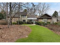 Charming stone and stucco home with well-manicured lawn and mature trees at 870 Waddington Ct, Atlanta, GA 30350