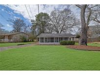 Charming home with a well-maintained lawn and a screened-in front porch, creating a cozy and inviting entrance at 2880 Hall Se Dr, Smyrna, GA 30082