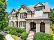 Charming brick-and-siding home with a meticulously landscaped front yard and covered porch entryway at 201 Beacon Cv, Canton, GA 30114