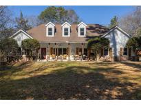 Charming ranch-style home with a covered porch and inviting red door, surrounded by mature trees and a spacious lawn at 3890 Irwin Bridge Nw Rd, Conyers, GA 30012