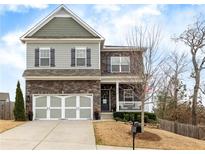 Charming two-story home with stone accents, neutral siding, large driveway, and manicured landscaping at 213 Augusta Walk, Canton, GA 30114