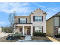 Charming two-story home with brick and siding, complemented by a cozy front porch and manicured landscaping at 855 Venture Sw Way, Atlanta, GA 30331